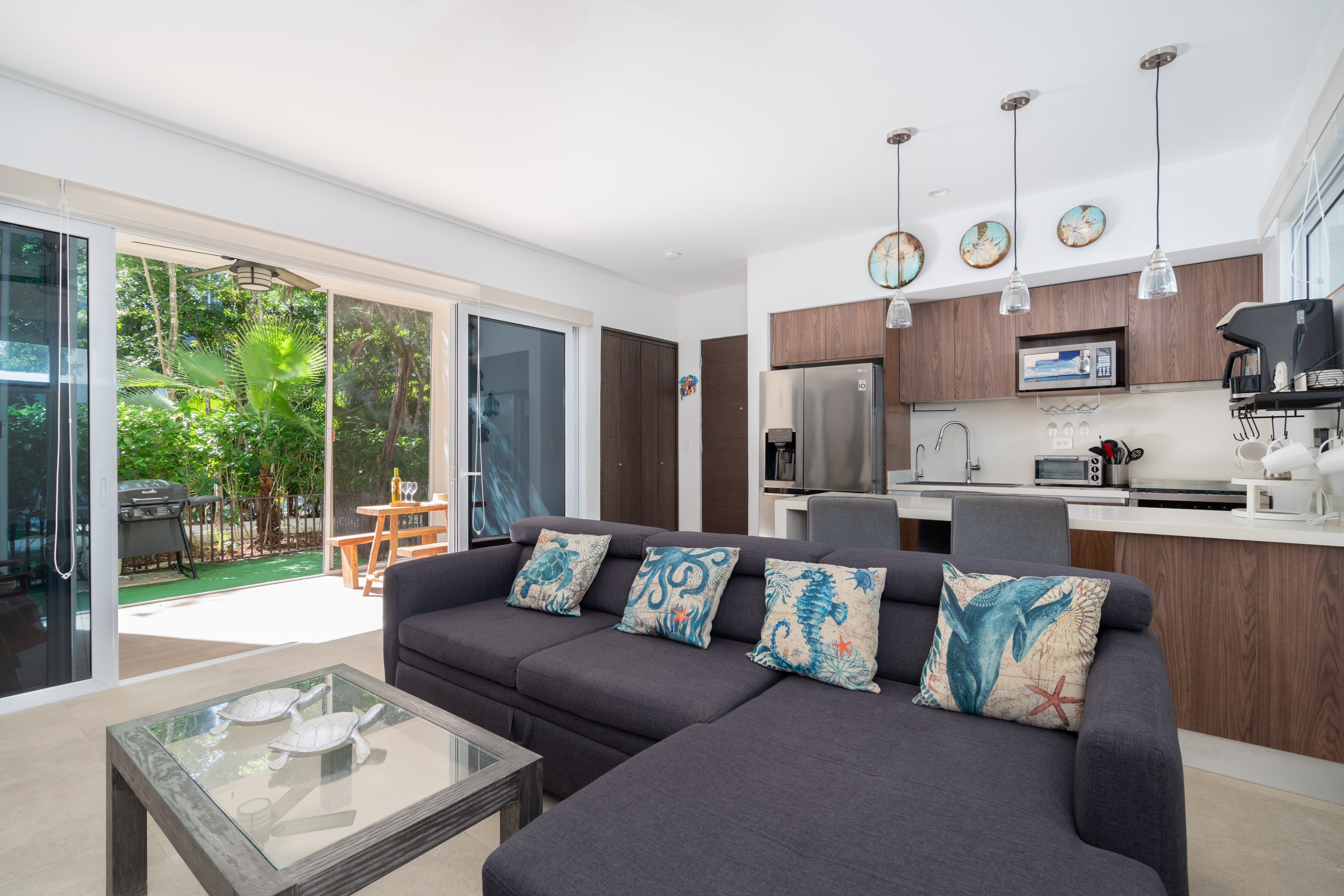 TAO Tulum G115 living room and kitchen opening onto the screened terrace